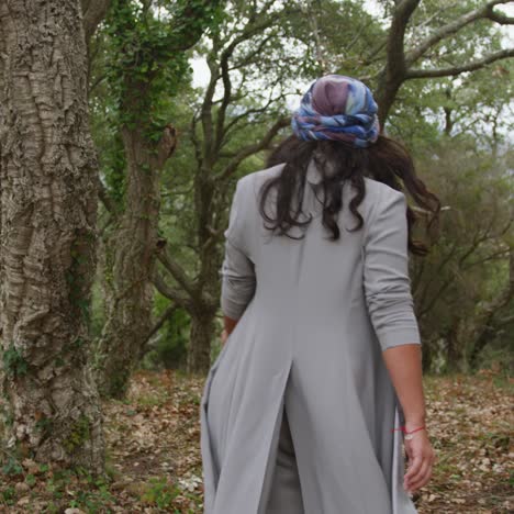beautiful young woman walking through the autumn forest