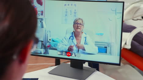 back view of nurse discussing on webcam with senior stomatologist