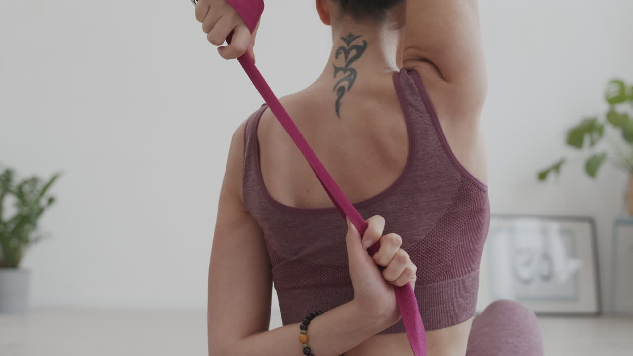 joven usando el cinturón de yoga durante el entrenamiento