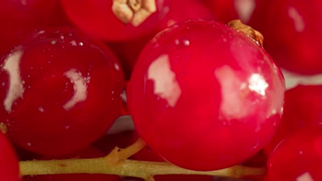 una macro muy cercana de una grosella roja en una mesa de madera.