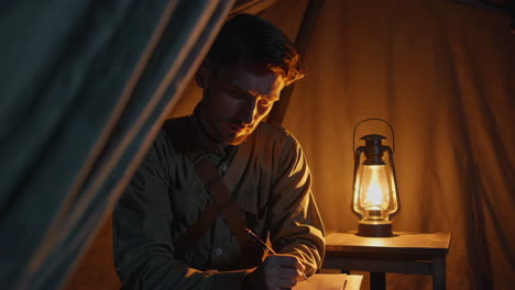 soldier writing in camp at night