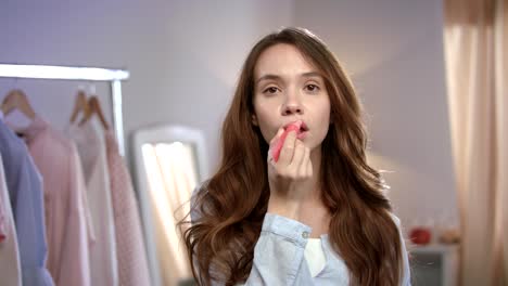 Young-woman-applying-liquid-lipstick-at-home.-Pretty-girl-makeup-at-morning