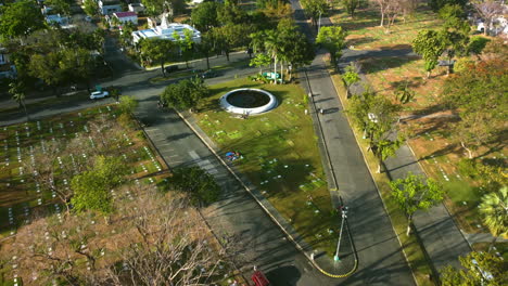 Aerial-view-tilting-toward-the-MMP-fountain,-in-sunny-Metro-Manila,-Philippines