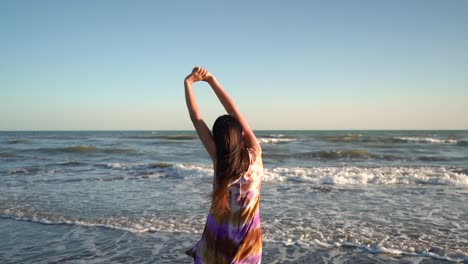 back view of a woman stretching on the beach - medium shot
