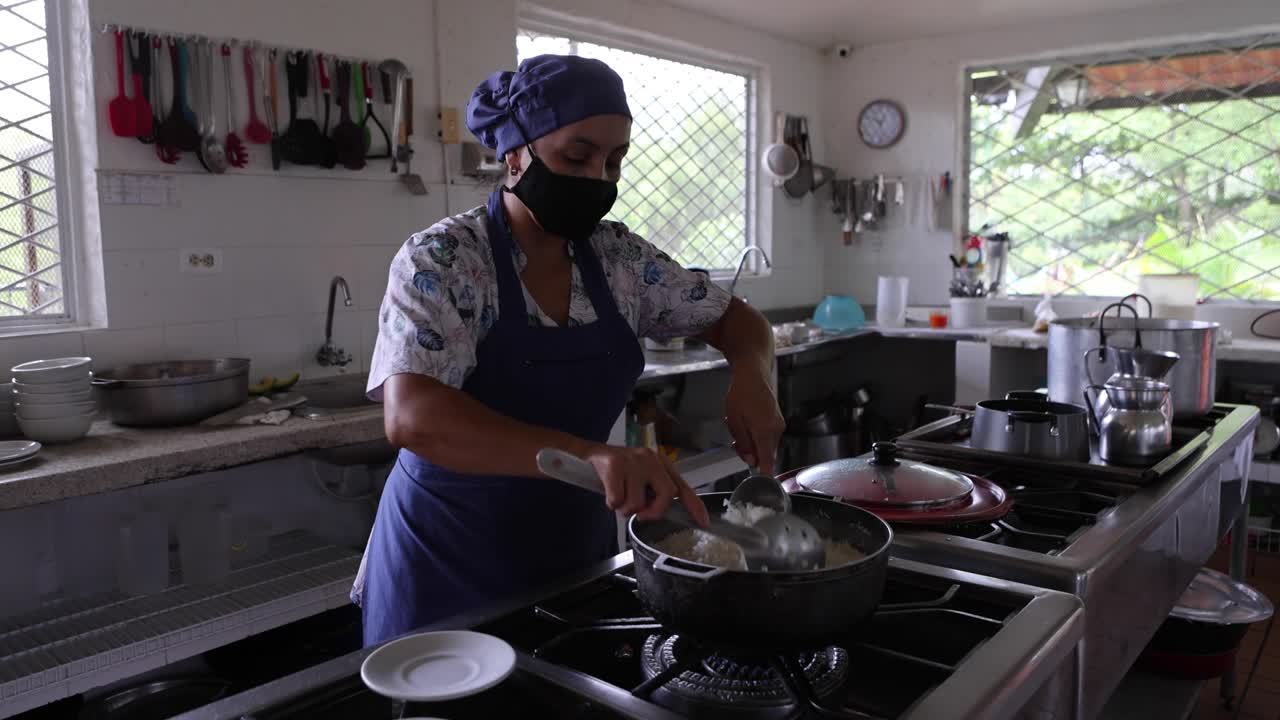 Cozinheira preparando arroz na cozinha de um restaurante