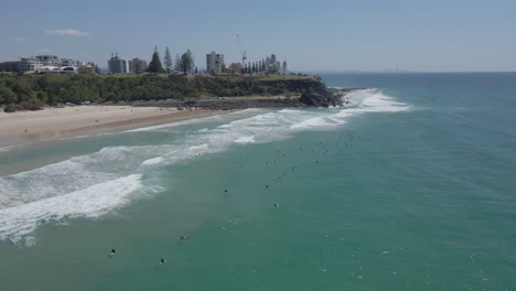 Tourist,-Der-Mit-Surfbrettern-Um-Den-Strand-Von-Duranbah-In-Gold-Coast,-Queensland,-Australien-Schwimmt