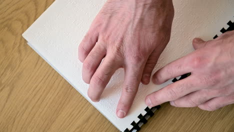 close up of an unrecognizable blind man reading a braille book