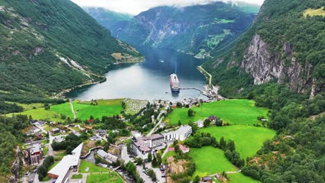 aerial view of cruise ship in fjord in front of geiranger village