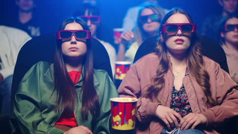 scared girls gesticulating in cinema.