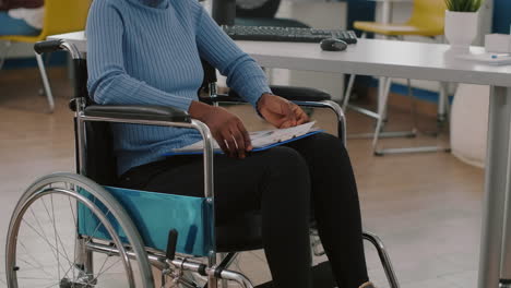 Paralized-handicapped-sitting-immobilized-in-wheelchair-holding-clipboard