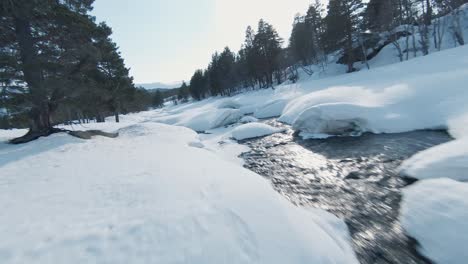 majestic frosty winter river in norway snowy landscape, fpv aerial view