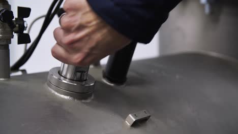 technician installing a pressure sensor on a large tank