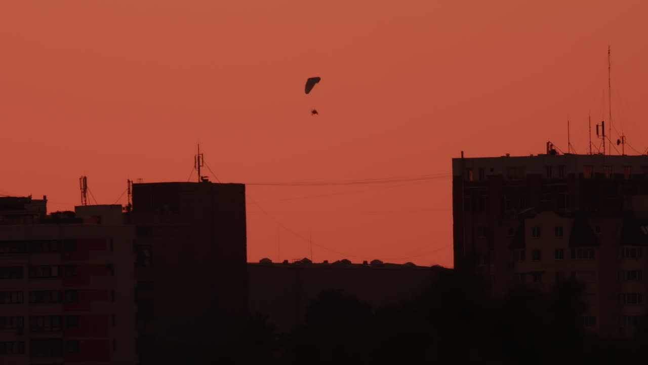 Un paramotor se desliza suavemente por un cielo cálido al atardecer