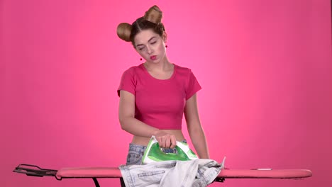 woman ironing clothes while on the phone