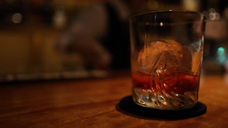 bartender stirring a drink with ice in a glass