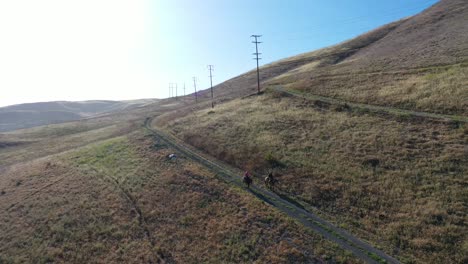 Beautiful-Aerial-Of-Retired-Retirement-Couple-Riding-Horses-Horseback-On-A-Mountain-Ranch-In-Santa-Barbara-California-1