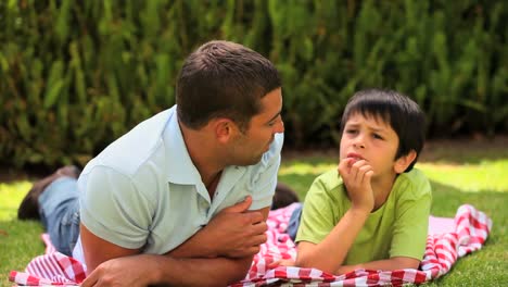 Vater-Und-Sohn-Liegen-Plaudernd-Auf-Dem-Rasen