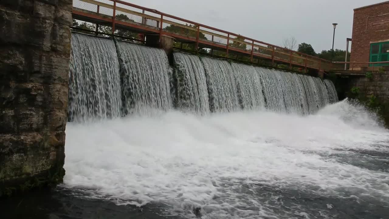approaching a dam with flowing water close up 4k 30fps drone