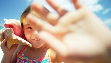 retrato de una niña en la playa sosteniendo una concha de concha