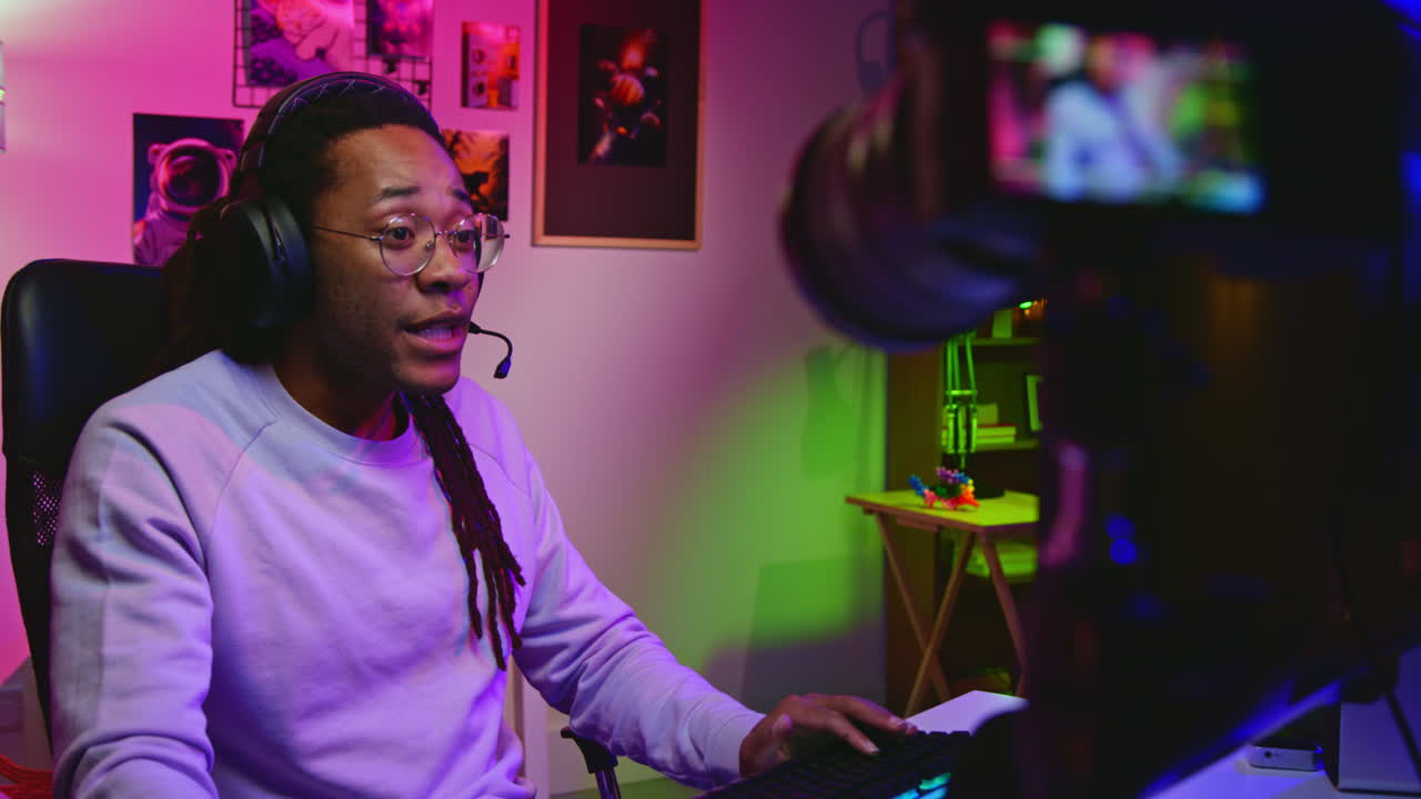 A young African American man streams on Twitch or Youtube from his home studio