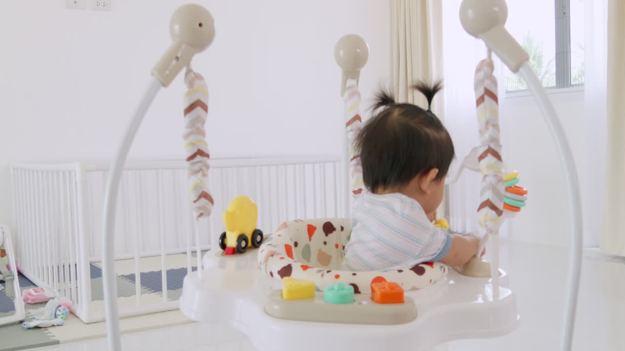 A joyful baby girl engages in playful activities in her vibrant nursery showcasing loving care.