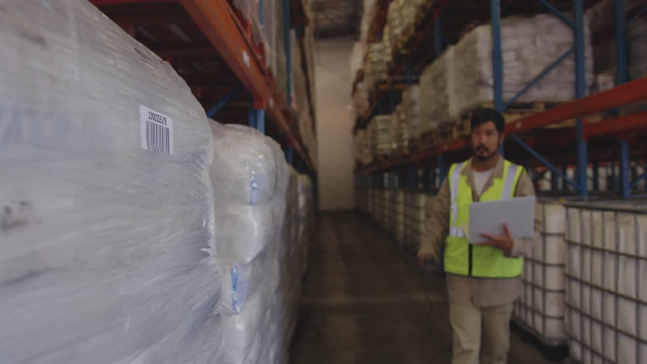 Warehouse worker using scanner intensifying HUD analytics and checking tablet for stock control