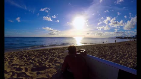 surfista con una tabla de surf sentado en la playa 4k