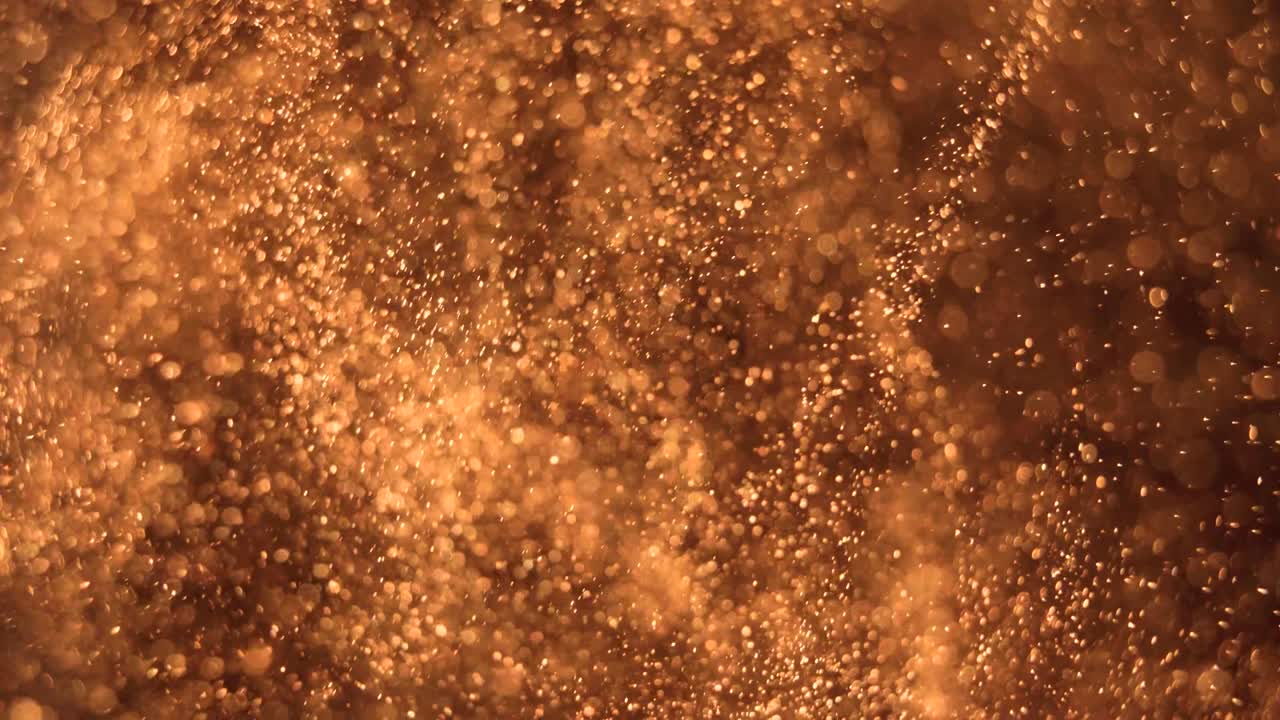 Elegant, detailed, and golden particles flow with shallow depth of field underwater
