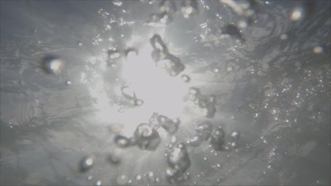 river water flows past creating bubbles with reflected sunshine - waimakariri river