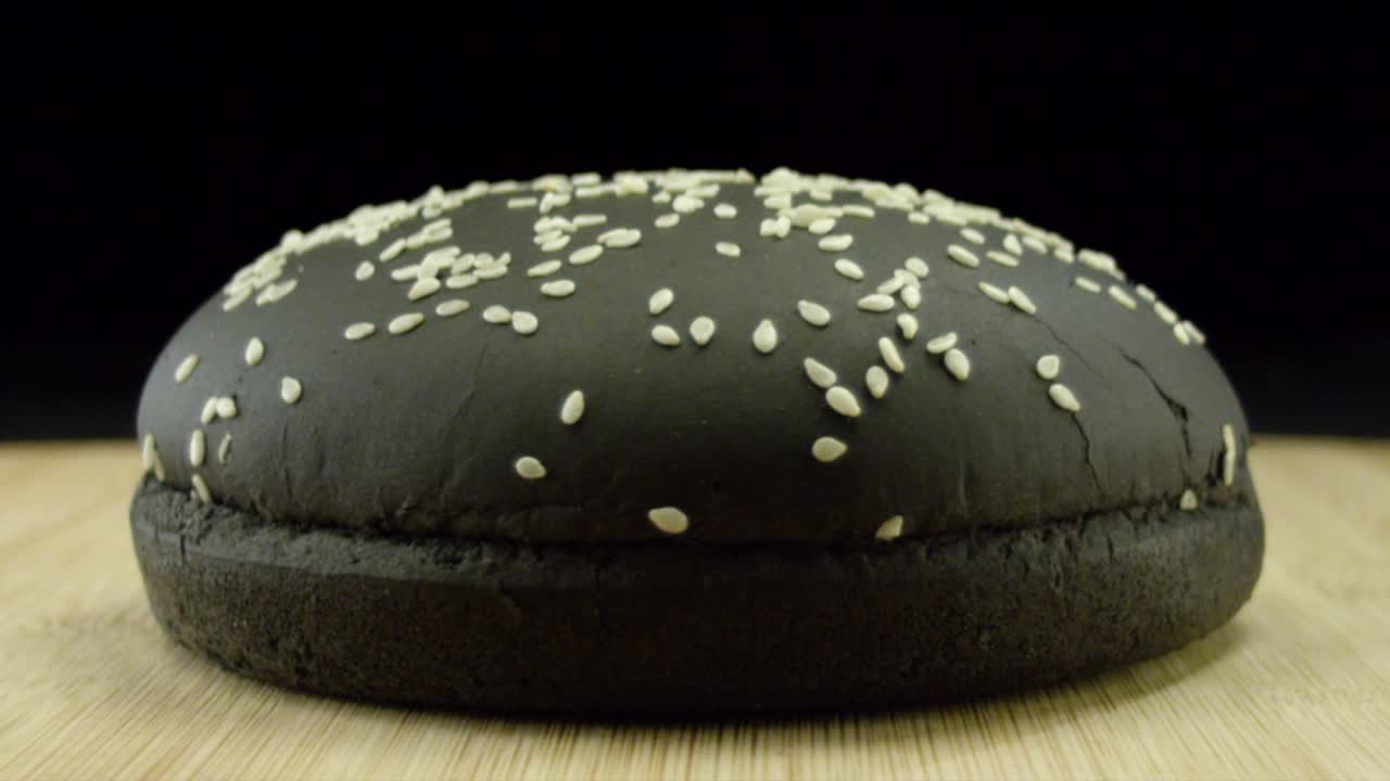 persona que trabaja en una computadora portátil y un pan de sésamo negro