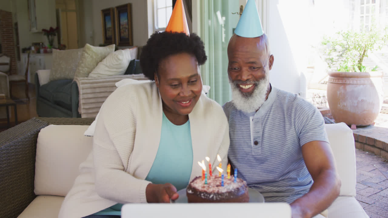 una feliz pareja de ancianos afroamericanos con sombreros de fiesta