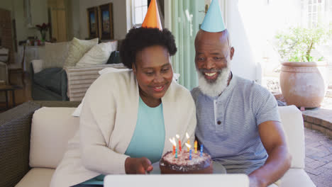 una feliz pareja de ancianos afroamericanos con sombreros de fiesta