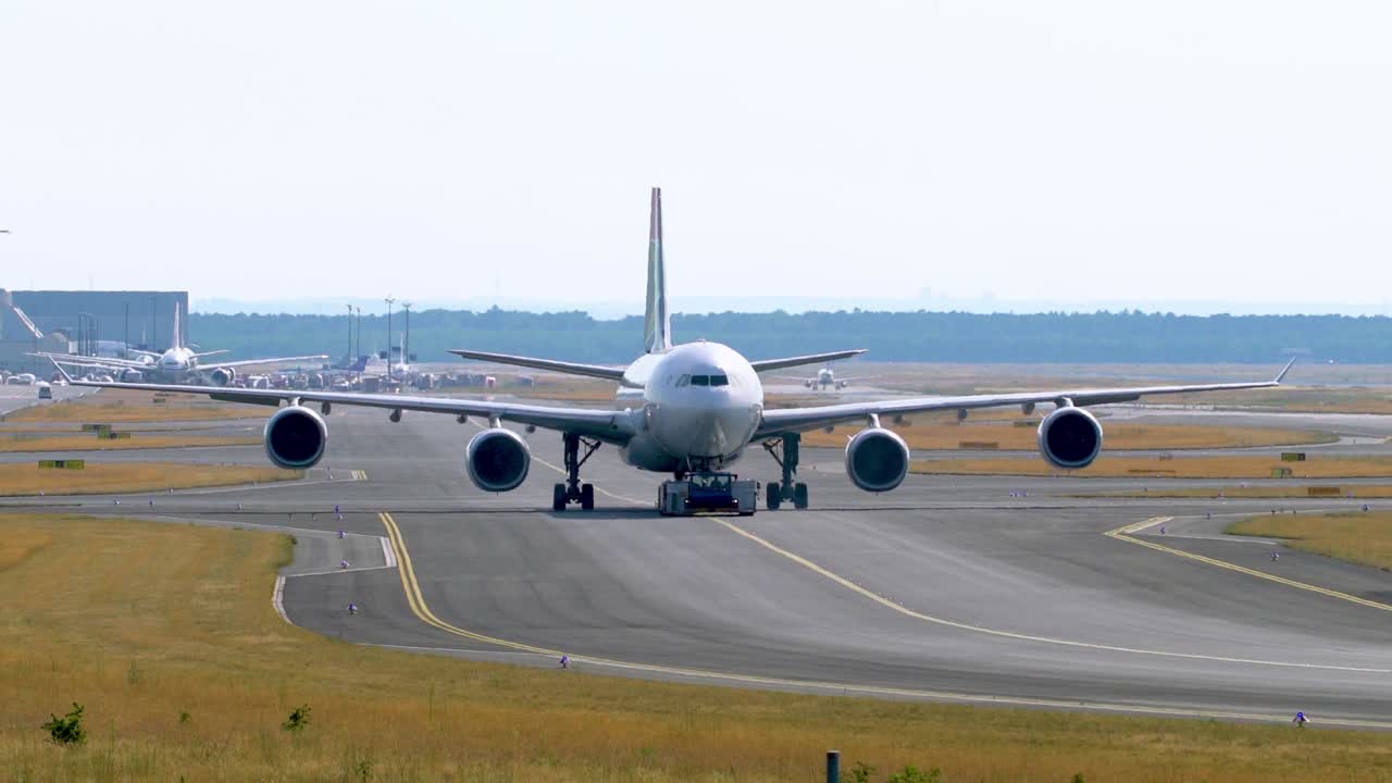 tractor de remolque remolcando un avión de pasajeros en la pista del aeródromo
