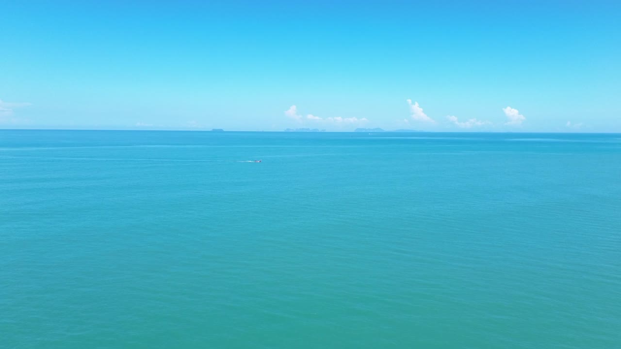 Filmagem aérea com drone de um pássaro solitário descansando em uma costa rochosa em Koh Lanta, com o oceano aberto no plano de fundo, criando uma cena minimalista e tranquila da vida selvagem costeira, sem pessoas.