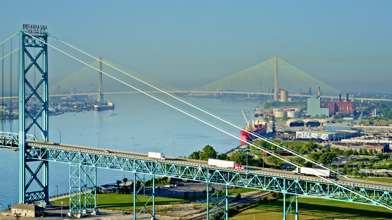 Drone footage sweeping above the Detroit River, capturing freighter traffic and urban skyline
