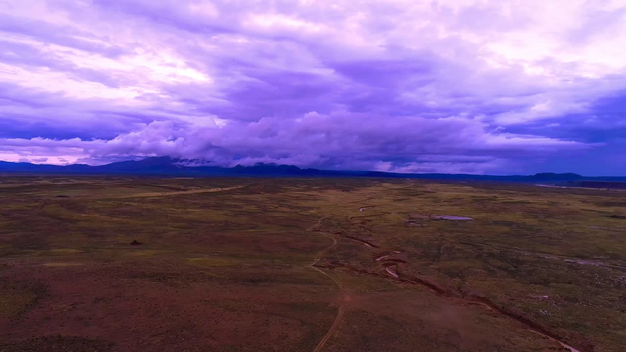 ruta atravesando el desierto donde se puede ver una pequeña granja y un río serpenteante