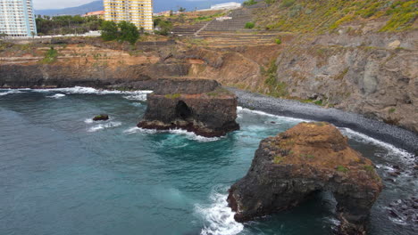 playa de los rocas, tenerife: vista aérea en órbita y cerca de las dos formaciones rocosas de la famosa playa de tenerife