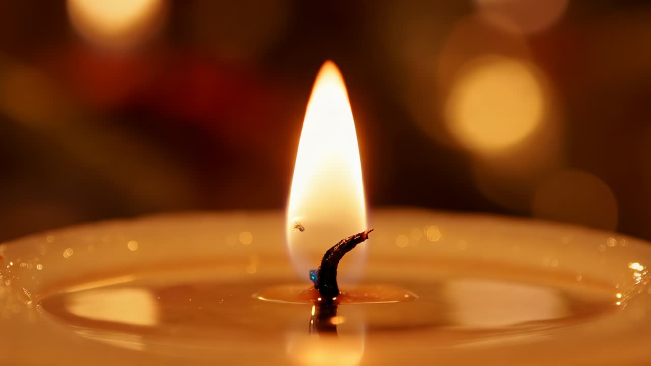 Fiamma tremolante di una candela, stoppino bruciato che reagisce a una macchiolina, pozza di cera increspata su un tavolo con un caldo effetto bokeh