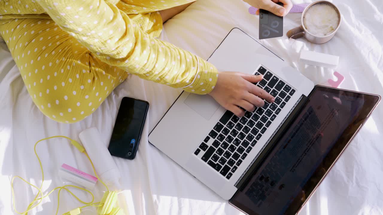 mujer en pijama amarilla paga con tarjeta de crédito en línea