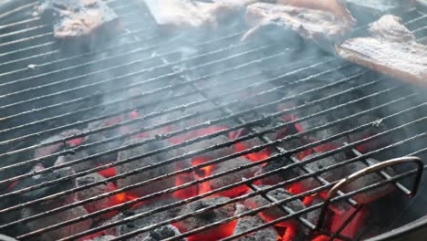 pork spare ribs grilling on a charcoal bbq and adding one more