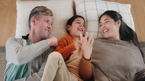 Mom,-dad-and-kid-laughing-on-bed