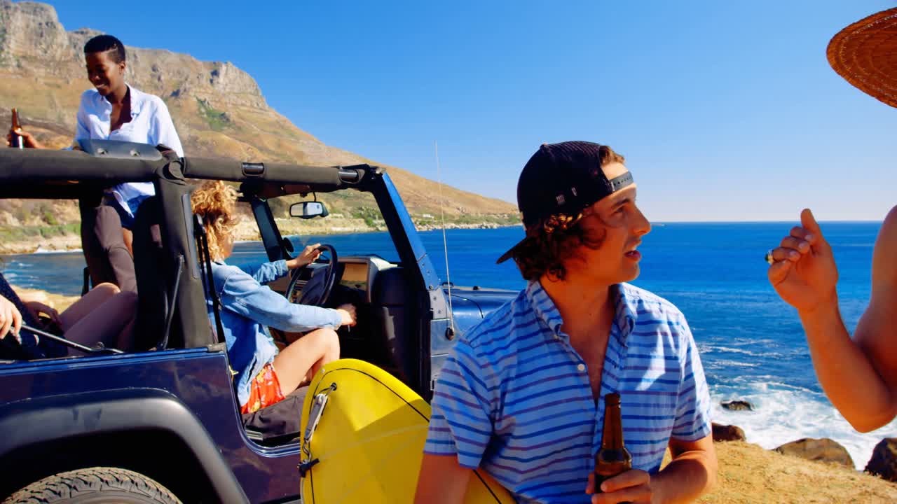 해변 4k에서 서로 상호 작용하는 남성 친구들