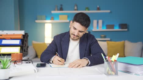 el joven empleado está pensando mientras toma notas.