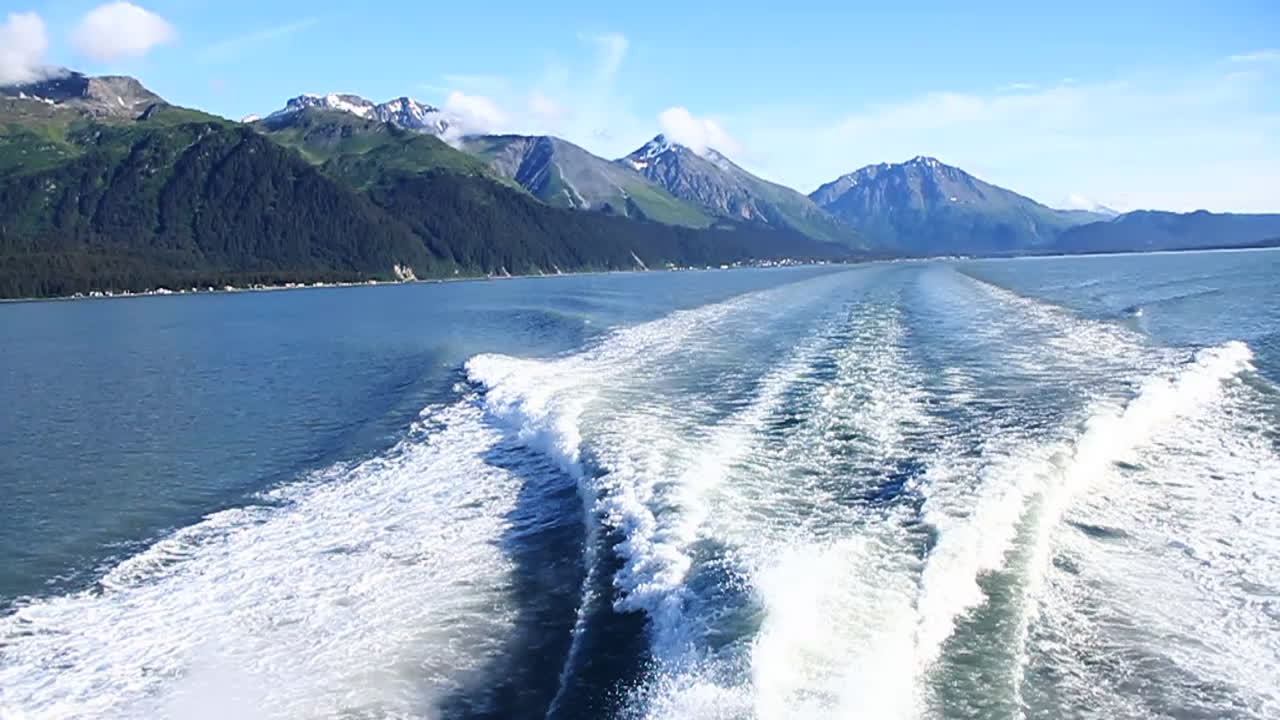 알래스카를 배경으로 산이 있는 보트 웨이크 파도