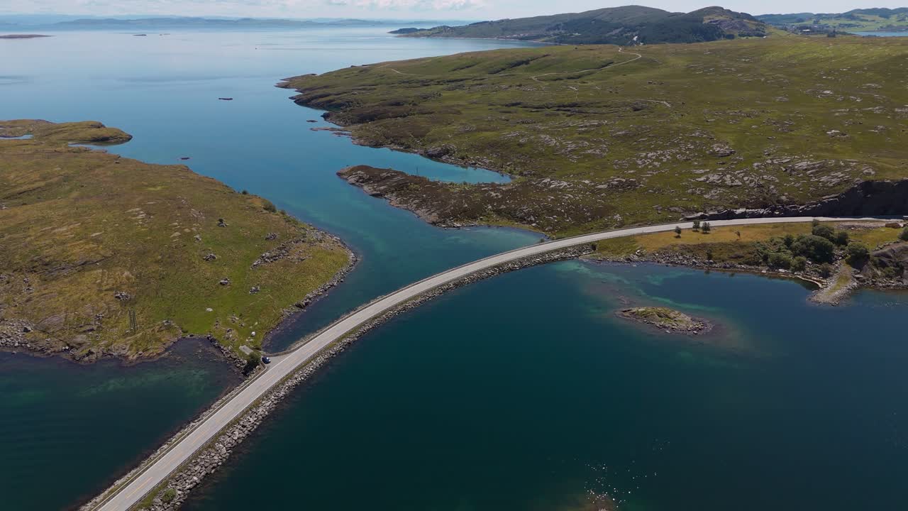 Atlantic Ocean Road. Cars driving over bridge across Fjord with clear blue and turquoise sea water at Kristiansund