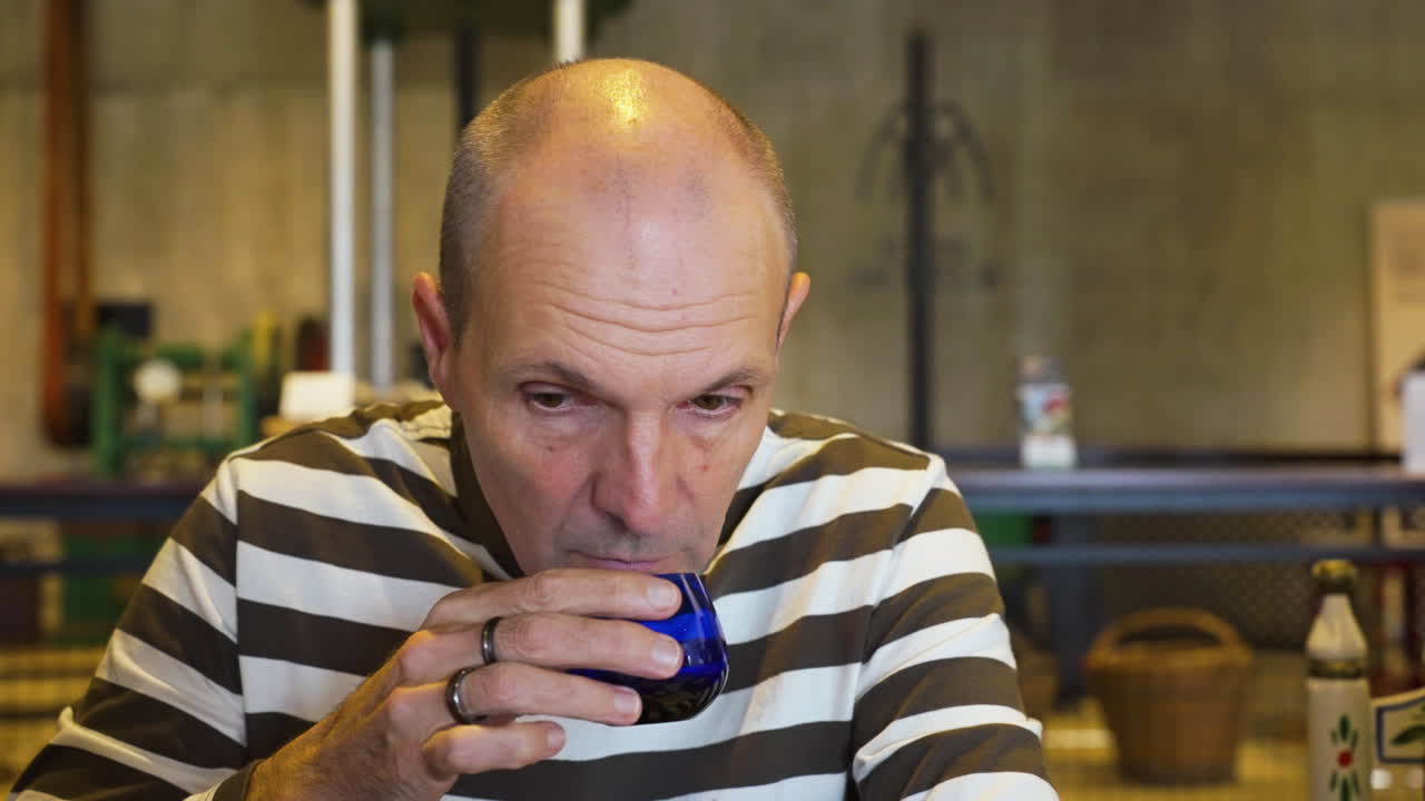 Tourist man taste fresh virgin olive oil in production facility