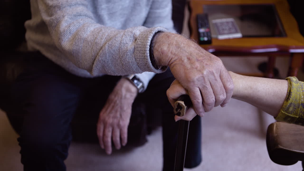 Elderly people holding hands for support