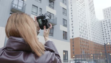 woman taking pictures of buildings in city