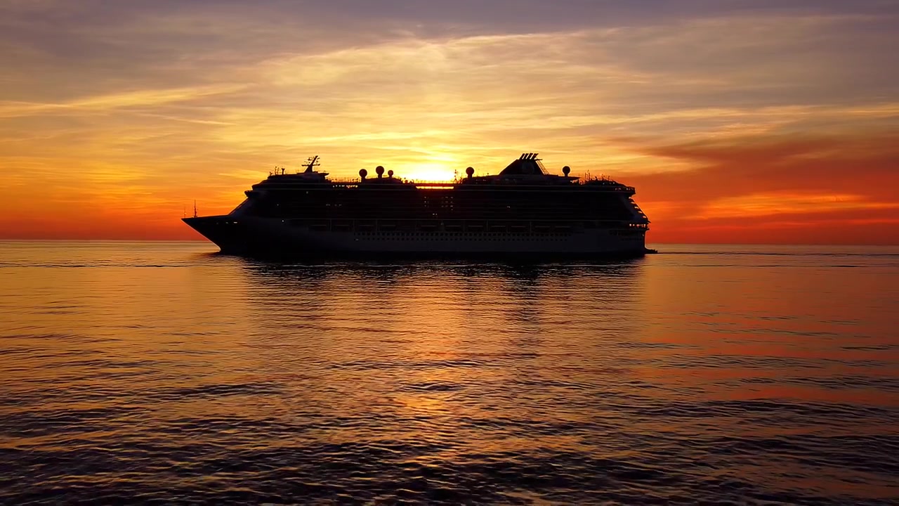 Silhouette of a luxury cruise ship at golden sunset