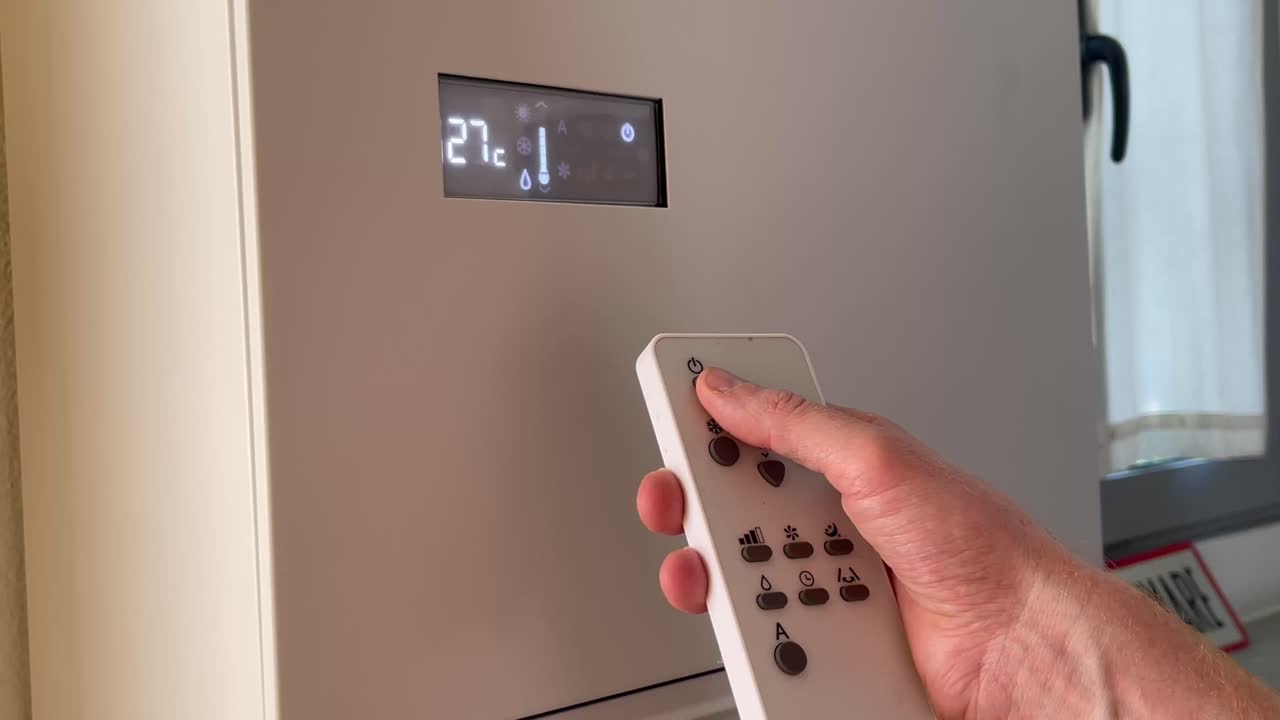 Close-up of hand operating air conditioner remote, lowering temperature to 23°C. Concept of smart control, comfort, and energy-efficient home cooling.